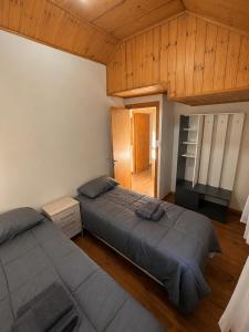 two beds in a bedroom with wooden ceilings at Destino Patagonia in Esquel