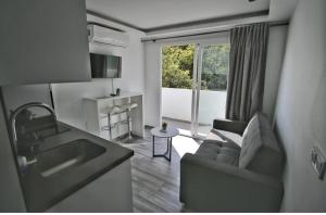 a living room with a couch and a kitchen at Marbella-Peñuelas Old Town Apartments in Marbella
