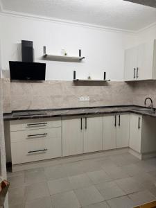 a kitchen with white cabinets and a sink at Пані Анна in Kamianets-Podilskyi