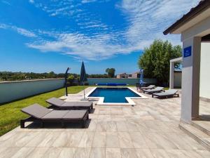 a patio with lounge chairs and a swimming pool at Villa Alba in Vodnjan
