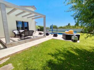 a patio with a table and chairs and a pool at Villa Alba in Vodnjan