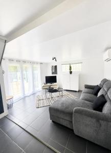 a living room with a couch and a table at Petite maisonnette avec accés piscine in Montauban