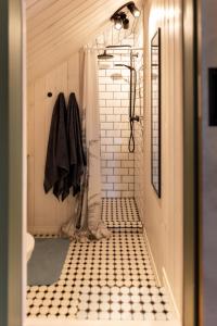 a bathroom with a shower and a black and white tile floor at Lendle Peace & Wellness Stay Märjamaa in Märjamaa