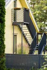 a house with a black deck and stairs on it at Lendle Peace & Wellness Stay Märjamaa in Märjamaa