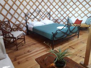 a bedroom with a bed and two chairs in a yurt at séjourner en yourte in Gans