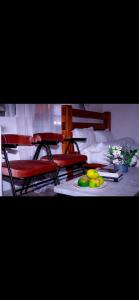 a table with a plate of fruit and two chairs at MPD Deluxe Suites in Kakamega