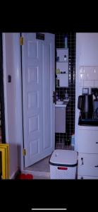 a kitchen with a white door and a white toilet at MPD Deluxe Suites in Kakamega +2 photos