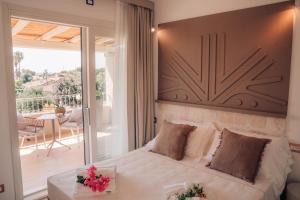 a bedroom with a bed and a balcony at Lentischi Hotel - Adults Only in Villasimius +82 photos