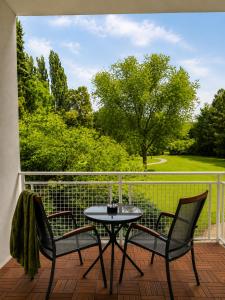 a patio table and two chairs on a balcony at Boutique Hotel at Golf Piestany in Piešťany