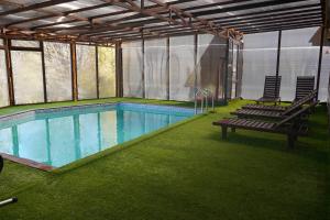 a swimming pool with two chairs and a bench at GLAMPING WOLF MOUNt in Margahovit