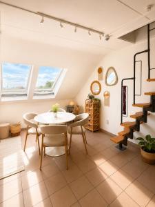 a dining room with a table and chairs and stairs at Cozy duplex apartment with free parking in Leuven
