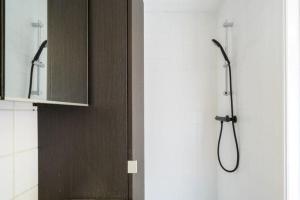 a shower in a bathroom with a sink and a mirror at Cozy duplex apartment with free parking in Leuven