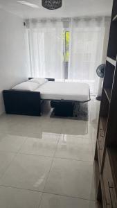 a bed sitting in a room with a window at Studio cosy Ducos in Ducos