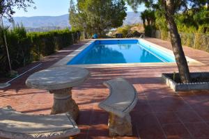 a swimming pool with a table and chairs next to it at Casa de desierto in Tabernas