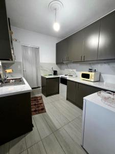 a kitchen with black cabinets and white appliances at Chora Residence in Khóra