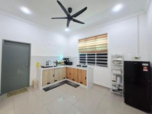 a kitchen with a ceiling fan and a black refrigerator at D'Biru Homestay Segamat in Segamat +10 photos