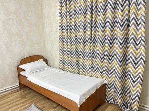 a small bedroom with a bed with a zebra at DARAI guest house Hostel Turkistan in Türkistan