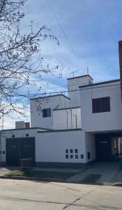 a large white building with a parking lot at La moora in Alta Gracia