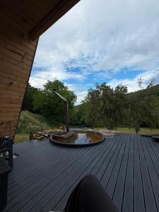 a large wooden deck with a fire pit on it at Cabana La Poiata in Valea Chioarului