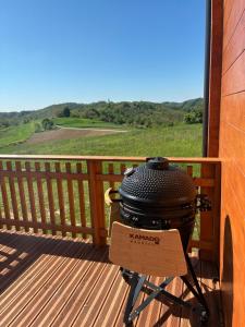 a grill on a deck with a view of a field at Apartman Andrej in Kolarec