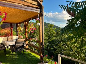a patio with a table and chairs and flowers at Natural House in Visoko