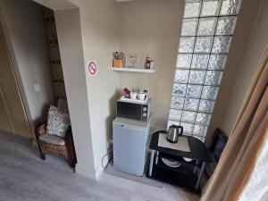 a small kitchen with a microwave and a table at Palm Zicht in Cape Town