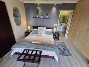 a bedroom with a large bed and a mirror at Palm Zicht in Cape Town