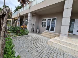 a house with a brick walkway in front of it at Palm Zicht in Cape Town