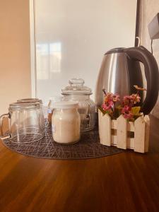 a table with jars and flowers and a tea kettle at La moora in Alta Gracia