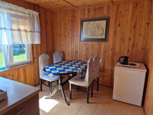 a kitchen with a table and chairs in a room at Dom pod lipą in Łeba
