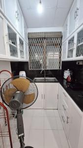 a kitchen with white cabinets and a fan at Vacation Villa - Katunayake in Kotugoda +29 photos