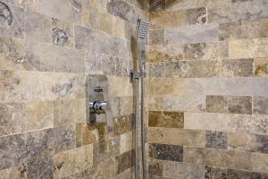 a shower in a bathroom with a tile wall at Cataleya House in Oeşti-Pămînteni +74 photos