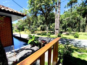 a porch of a house with a wooden railing at Fox pousada das águas in Prudentópolis +14 photos