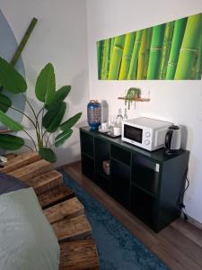 a room with a microwave on a black cabinet at Jungle Dream in Hitzkirch