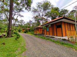 a small house on a dirt road next to a field at Fox pousada das águas in Prudentópolis