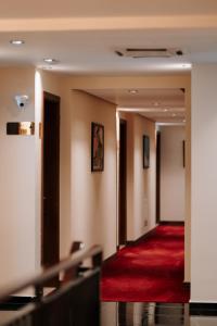 ein Hotelkorridor mit rotem Teppich in der Unterkunft Monarch Boutique Hotel in Prizren