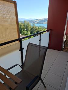 a chair on a balcony with a view of the water at Jungle Dream in Hitzkirch