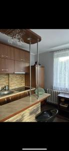 a kitchen with wooden cabinets and a counter top at Przytulna Kawalerka Łeba in Łeba