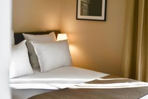 a bedroom with a bed with white pillows at Hotel Local 101 Beaurepaire in Paris