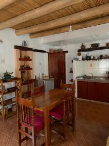 a kitchen with a wooden table and chairs in a room at WasyLopez in Maimará