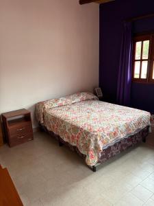 a bedroom with a bed and a wooden night stand at WasyLopez in Maimará
