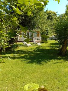 two benches sitting in the grass in a yard at Le Charme au Fil de l'eau in Neslette