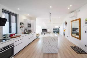 a large kitchen with white cabinets and a wooden floor at Monte Carlo Monaco Border - luxury, modern, cozy with home feelings and See View in Beausoleil