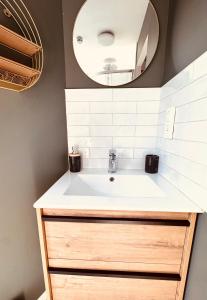 a bathroom with a sink and a mirror at Au petit Cachou in Port-Bail-sur-Mer