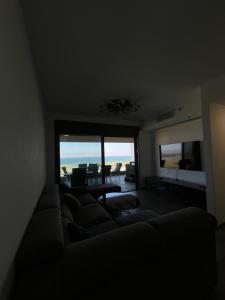 a living room with a couch and a view of the ocean at סוויטת נוף התכלת in Migdal