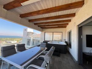 a dining room with a table and chairs and a television at סוויטת נוף התכלת in Migdal