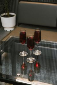 three wine glasses sitting on top of a table at Grey Courtyard Entire Studio Taj Mahal Parking 3KM in Agra