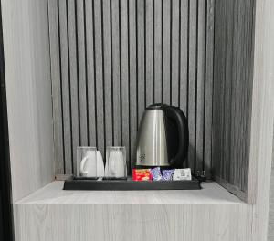 a shelf with two glasses and a tea kettle at Grey Courtyard Entire Studio Taj Mahal Parking 3KM in Agra
