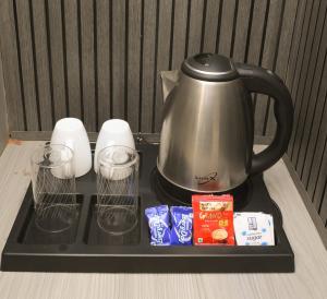 a tea kettle and cups on a tray with food at Grey Courtyard Entire Studio Taj Mahal Parking 3KM in Agra +15 photos