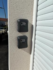 two thermostats on the side of a building at Appart orange 25 m2 neuf RDC in Sainte-Marie-aux-Chênes